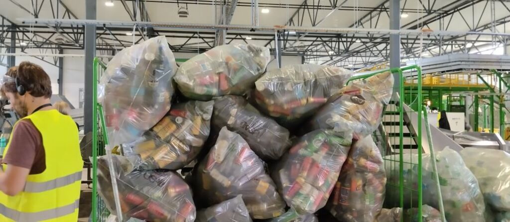 Запечатани чували с метални кенчета, които предстои да бъдат преброени, смачкани и балирани за рециклиране.